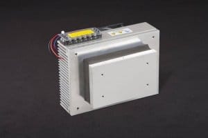 Three-quarter view of thermoelectric cold plate cooler/heater incorporating two thermoelectric modules. Cooled aluminum plate on the front, waste heat is exhausted to fins on back. Fins are fan cooled. The fan air enters on the middle back and exhausts on sides. Operates on 24 volts DC and removes 60 watts of heat at a 0°C temperature difference relative to ambient. Internal extender blocks improve the heat pumping capacity at larger temperature differences.