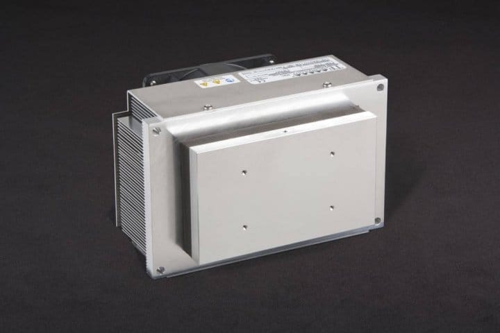 Three-quarter view of thermoelectric cold plate cooler/heater incorporating two large thermoelectric modules. Cooled aluminum plate on the front, waste heat is exhausted to fins on back. High density fins are fan cooled. The fan air enters on the middle back and exhausts on sides. Operates on 24 volts DC and removes 105 watts of heat at a 0°C temperature difference relative to ambient. Internal extender blocks improve the heat pumping capacity at larger temperature differences.